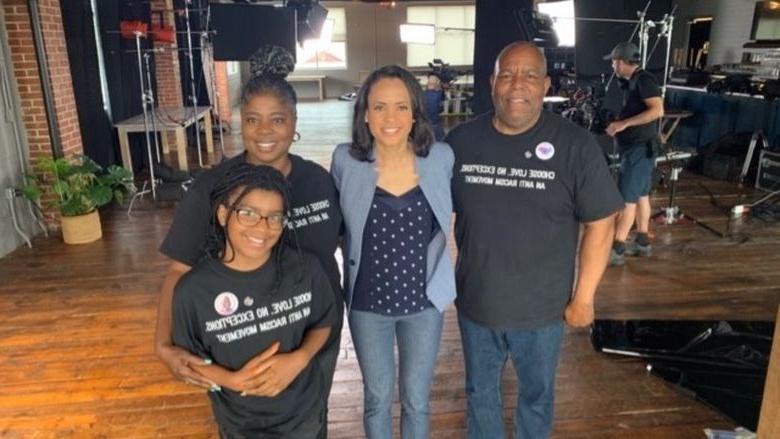 Family posing with female reporter 